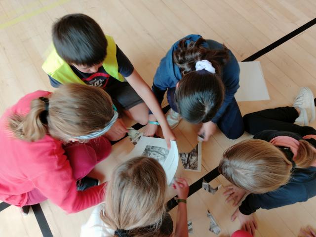 Des élèves en train de reconstituer un puzzle pour une énigme 